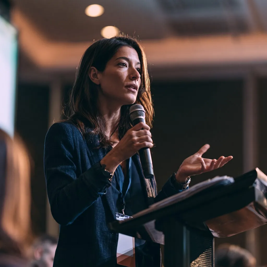 Keynote speaker presenting at podium with microphone